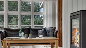 A cozy room with a leather sofa, a wooden table with drinks and glasses, and a fireplace. - 3 bedroom beautiful home in Hals (Hals)