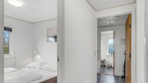 A bedroom with a bed, a window, and a door leading to a bathroom. - 3 bedroom beautiful home in Hals (Hals)