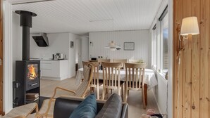 A cozy living room with a fireplace, a dining area, and a kitchen. - 3 bedroom beautiful home in Hals (Hals)