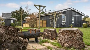 A rustic outdoor setting with a large metal bowl, wooden stumps, and a metal structure. - 3 bedroom beautiful home in Hals (Hals)