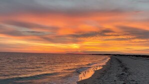 A beach at sunset with a clear sky and calm sea. - Newly Renovated Beach House w/ Central AC - 5min walk to the beach (Dennis)