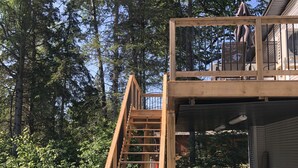 A wooden staircase leading to a deck on a cabin surrounded by trees. - Bachelor Suite Bed & Breakfast in Northern Muskoka (Huntsville)