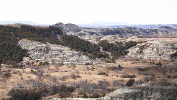 A panoramic view of a mountainous landscape with rocky terrain and sparse vegetation.