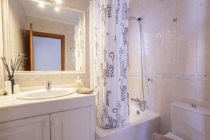 A bathroom with a white sink, mirror, and shower curtain with animal prints.