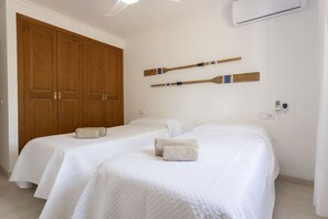 A hotel room with two beds, wooden wardrobe, and wall-mounted paddleboards. - 4 bedroom country house with pool and barbecue (Bunyola)