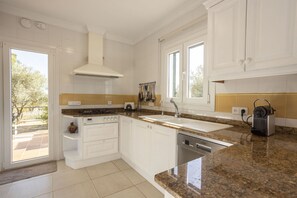A modern kitchen with white cabinets, granite countertops, a built-in oven, and a dishwasher. - 4 bedroom country house with pool and barbecue (Bunyola)