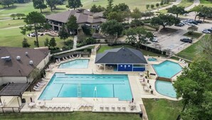 A large outdoor swimming pool area with multiple pools, lounge chairs, and a covered seating area. - New Waterfront House with Golf Cart!  (Montgomery)