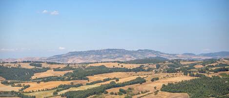 Vista panorámica de un paisaje montañoso con edificios dispersos, probablemente una zona rural con belleza natural.