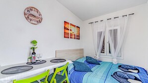 A bedroom with a bed, a desk, chairs, a clock, and artwork. - Gorgeous home in Potomje with WiFi (Potomje)