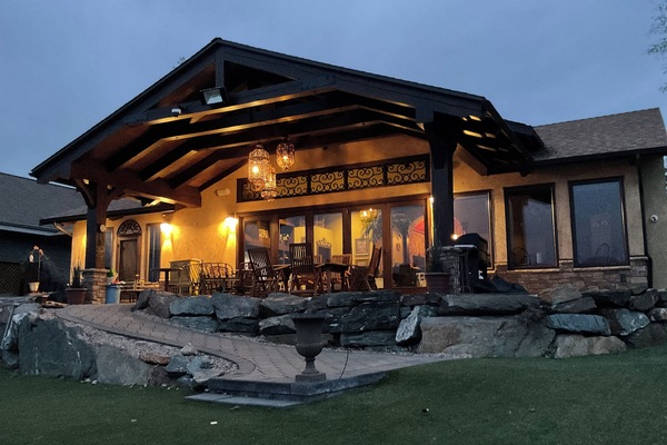 Spacious outdoor pation accessible to the front yeard leading to a sandy beach.