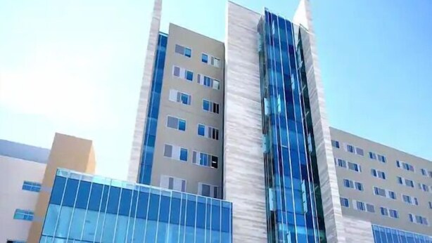 Un edificio moderno con varios pisos, ventanas amplias y fachada de vidrio.