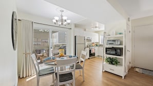 A modern kitchen with white cabinetry, a dining area with a round table, and a built-in microwave shelf. - LOWER Unit at Niguel Beach Terrace, Dana Point!  Close to Pool  view (Dana Point)