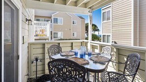 A covered outdoor patio with a table set for four, surrounded by metal chairs. - LOWER Unit at Niguel Beach Terrace, Dana Point!  Close to Pool  view (Dana Point)