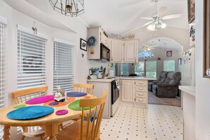 Enjoy a well-equipped kitchen with an oven, microwave, and dining area featuring a wooden table and chairs.