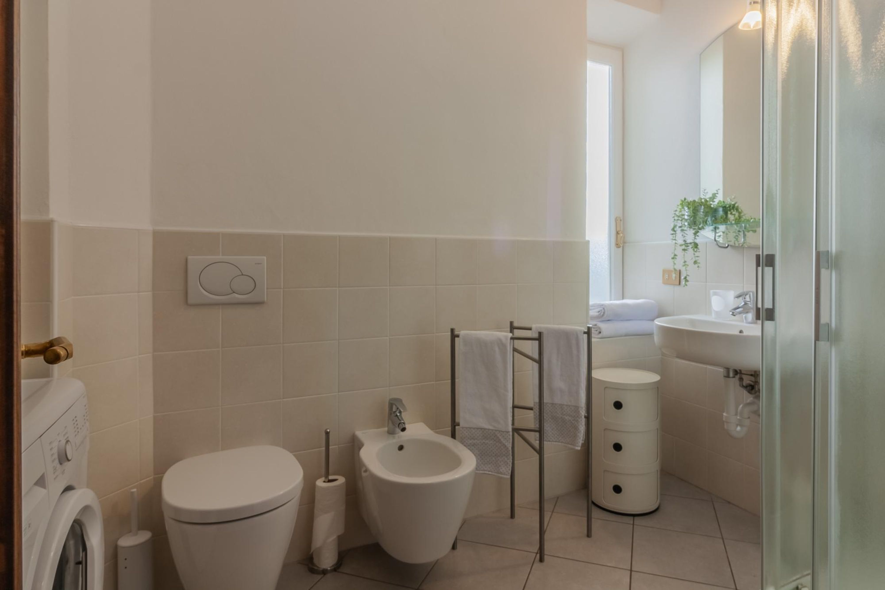 Egy modern fürőszoba, amelyben WC, bidé, törölközőtartó és mosdókagyló található.