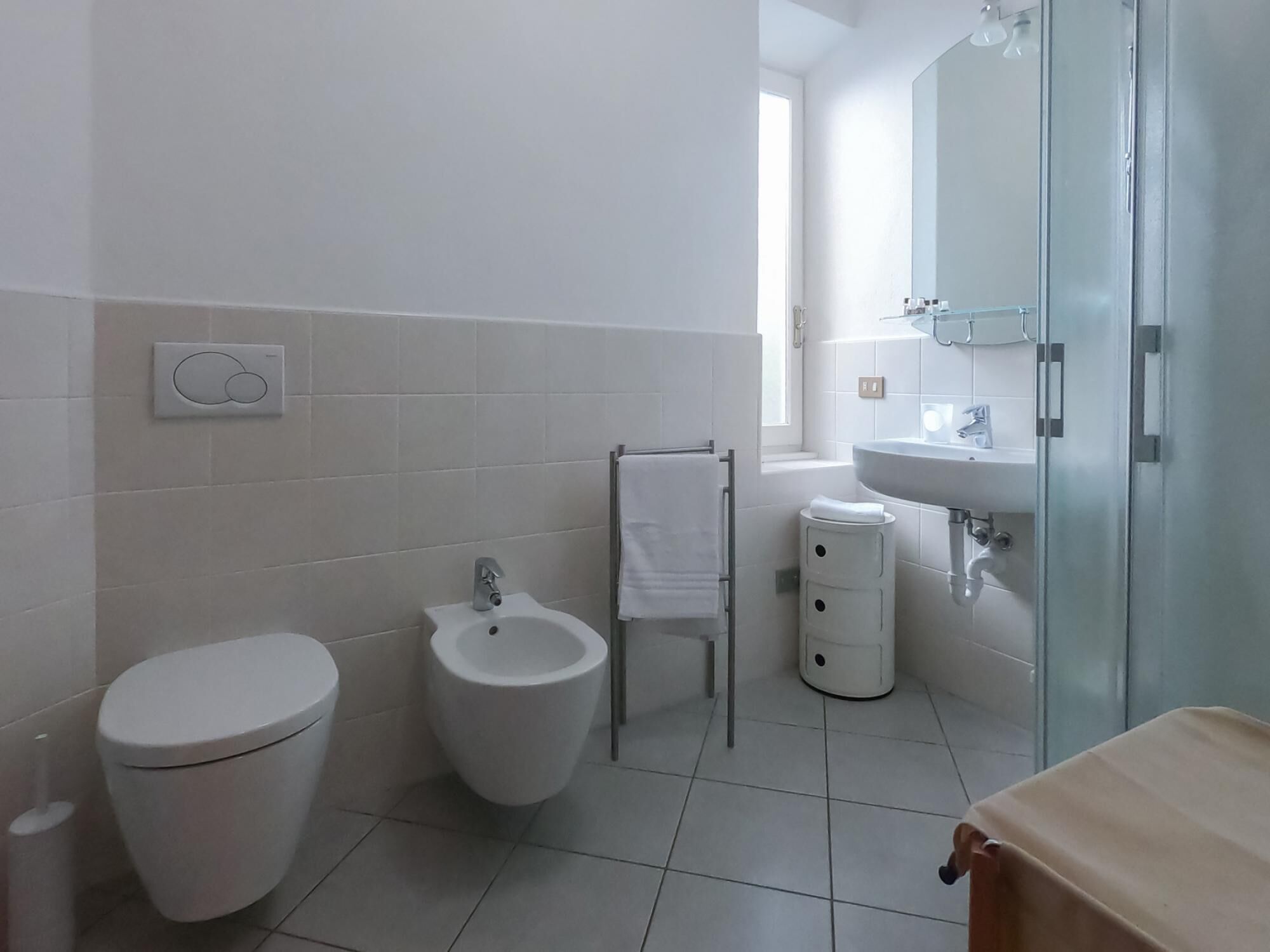 Ein modernes Badezimmer mit Toilette, Bidet und Waschbecken.
