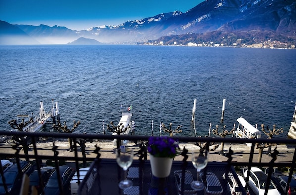 A view from a balcony overlooking a lake with mountains in the background.