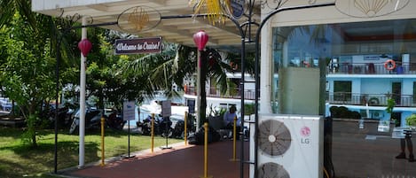 A covered outdoor area with a sign reading 'Welcome to Cruise!' and a sign for 'Le Journey Classic Cruise Luggage.'