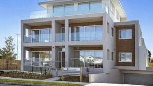 Un immeuble moderne à plusieurs étages, doté de grandes fenêtres et d’un toit plat.