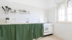 Eine Küche mit einem weißen Herd, einer Spüle und einem Fenster.