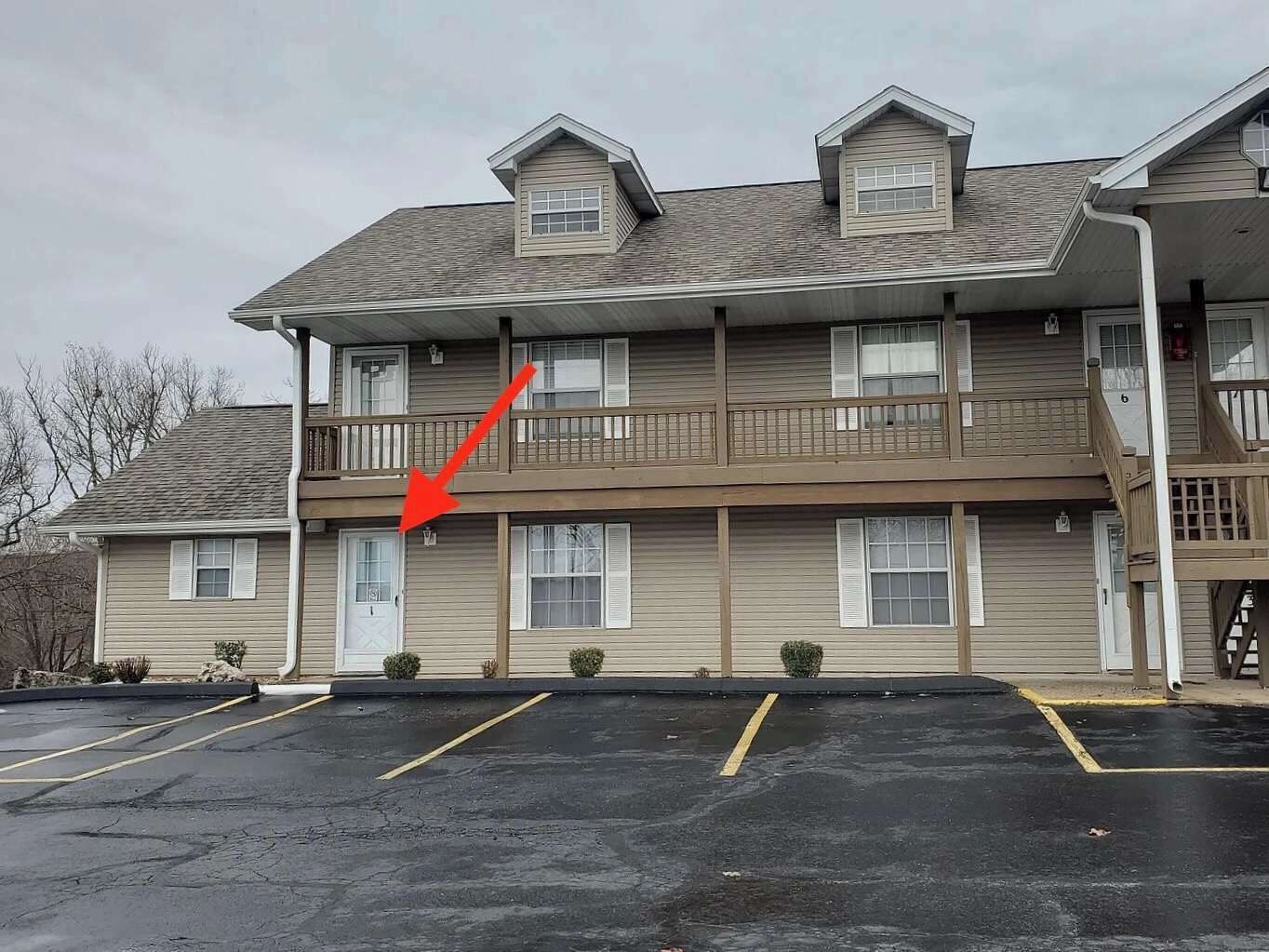 Un edificio a più piani con un parcheggio di fronte.