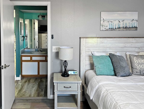 A bedroom with a bed, bedside table, lamp, and a painting on the wall. - 181 Walk In No stairs, Beautiful, Cozy, Huge Patio (Branson)