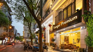 L’entrée d’un hôtel, avec une enseigne indiquant « Tunger Premium » et un numéro « 5 » précisant son emplacement.