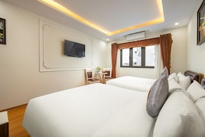 A hotel room with two beds, a TV mounted on the wall, a small table with chairs, and a window with curtains. - Tunger Premium Hotel (Hanoi)