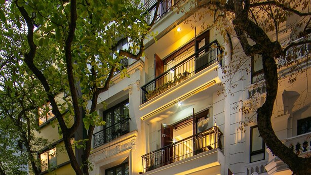 Un hôtel à plusieurs étages doté de balcons, un restaurant appelé « Tunger Premium » et une enseigne bien visible pour « V.I.T. TRADE ».