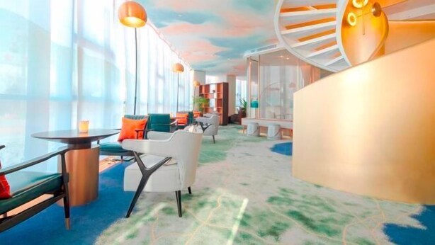 A modern hotel lobby with a spiral staircase, seating areas, and large windows. - Oriental Cobure Hotel (Weifang)