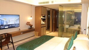 A modern hotel room with a bed, a desk, a television, and a wardrobe. - Oriental Cobure Hotel (Weifang)