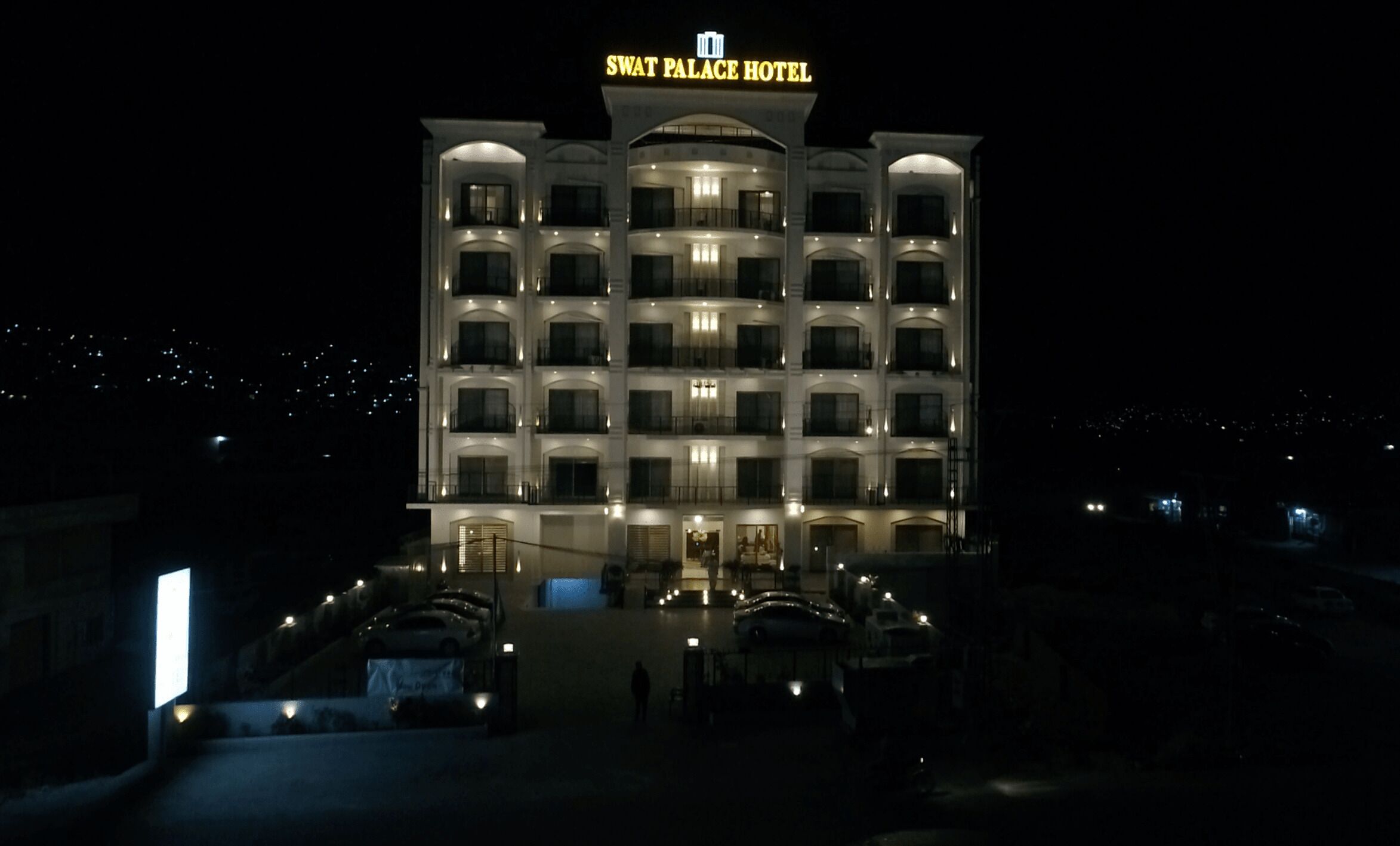 Un hotel de varios pisos con un letrero llamativo en la parte superior.