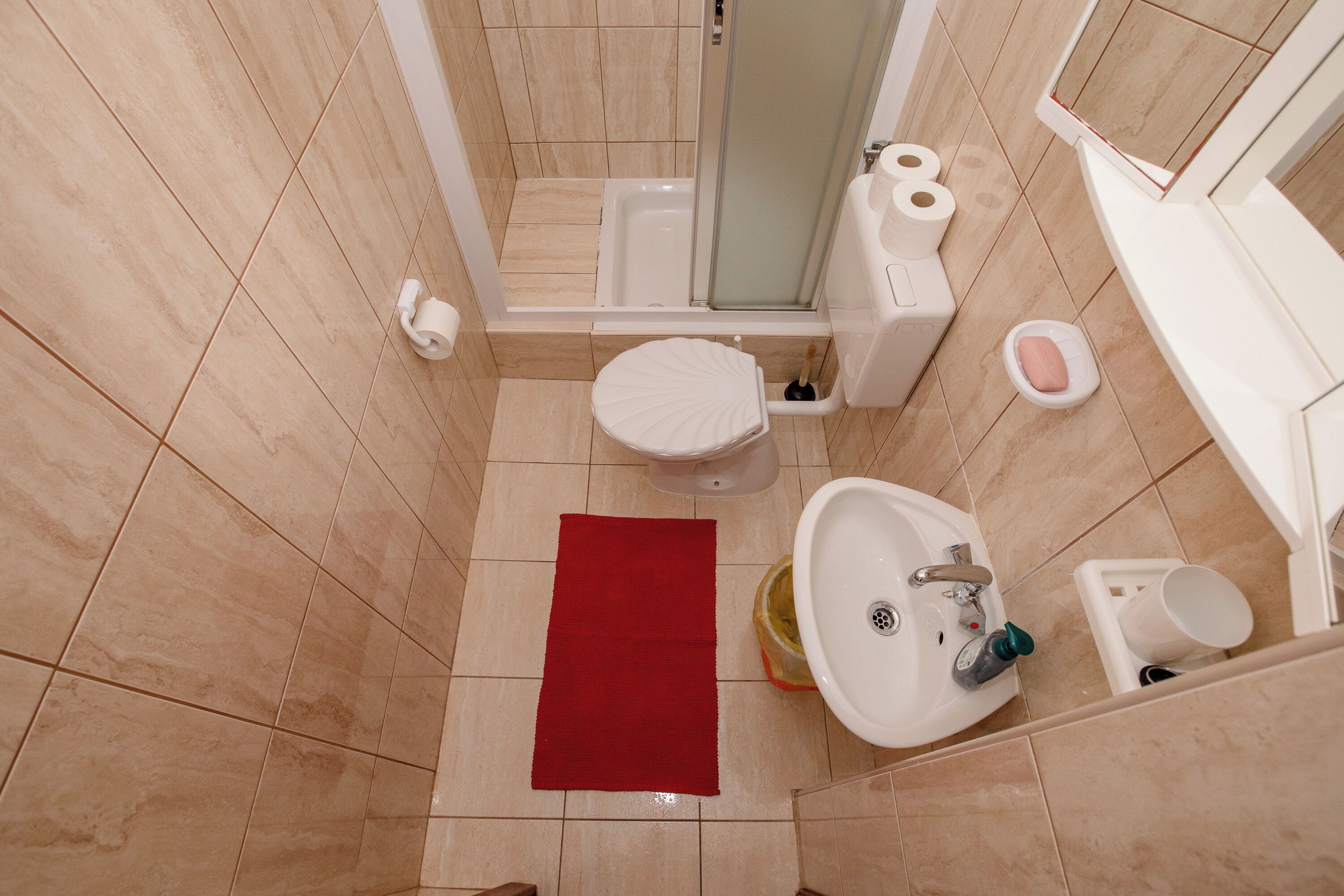 Un baño con inodoro, bidé, lavamanos y ducha.