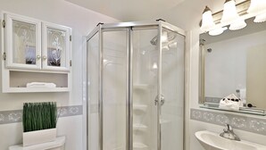 Ein Badezimmer mit Duschkabine, Waschbecken und Toilette.
