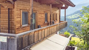 Eine Holzhütte mit Balkon und Blick auf eine Berglandschaft.