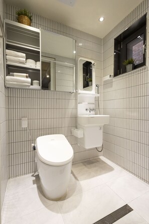 A modern bathroom with a toilet, sink, and mirror. - Designers ON:the zip in Mangwon #1 (Pocket-fi) (서울특별시)