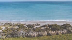 A beach with clear blue water and a sandy shore. - Stylish Beach House 4 BR w/pool - 1 min from the beach! (Rhodes)