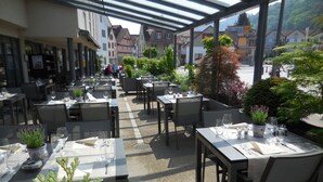 An outdoor dining area with tables and chairs, surrounded by buildings and greenery. - Apartment Dufour (Rheineck)