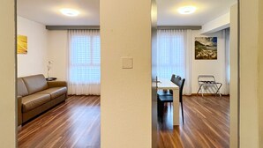 A spacious living area with a sofa, dining table, and chairs. - Apartment Dufour (Rheineck)