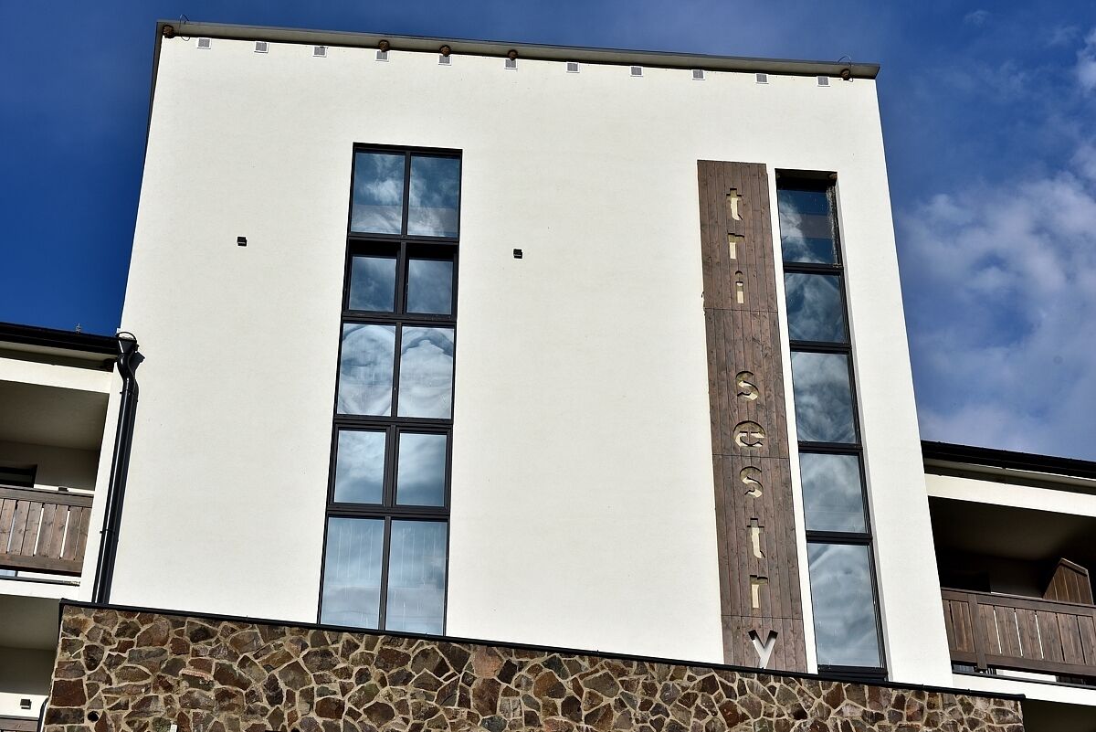 A building with a white facade, large windows, and a stone base.