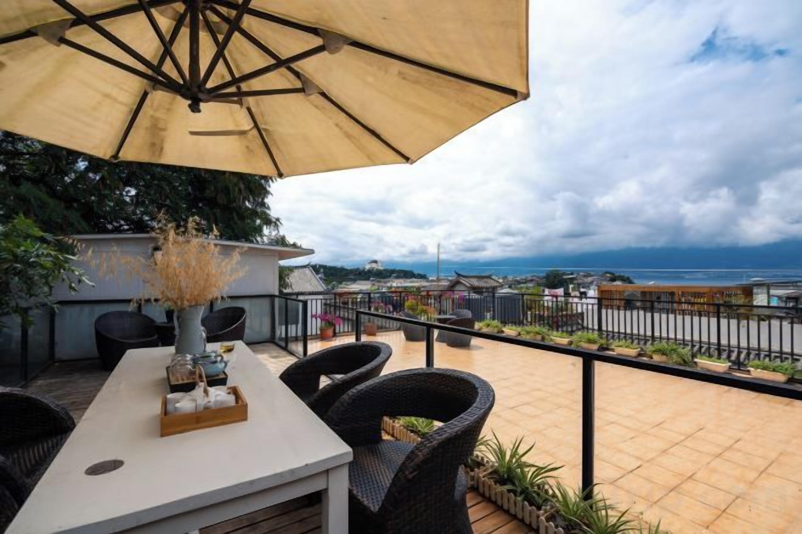 An outdoor patio with a table, chairs, and an umbrella.