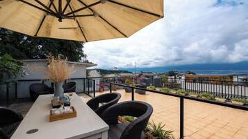 Un patio al aire libre con una mesa, sillas y una sombrilla.