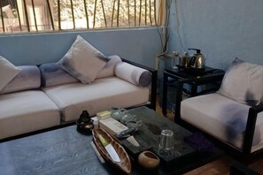 A living room with a sofa, a coffee table, and a side table with kitchen items. - Dali Manglietia Soft Boutique Residence (Dali City)