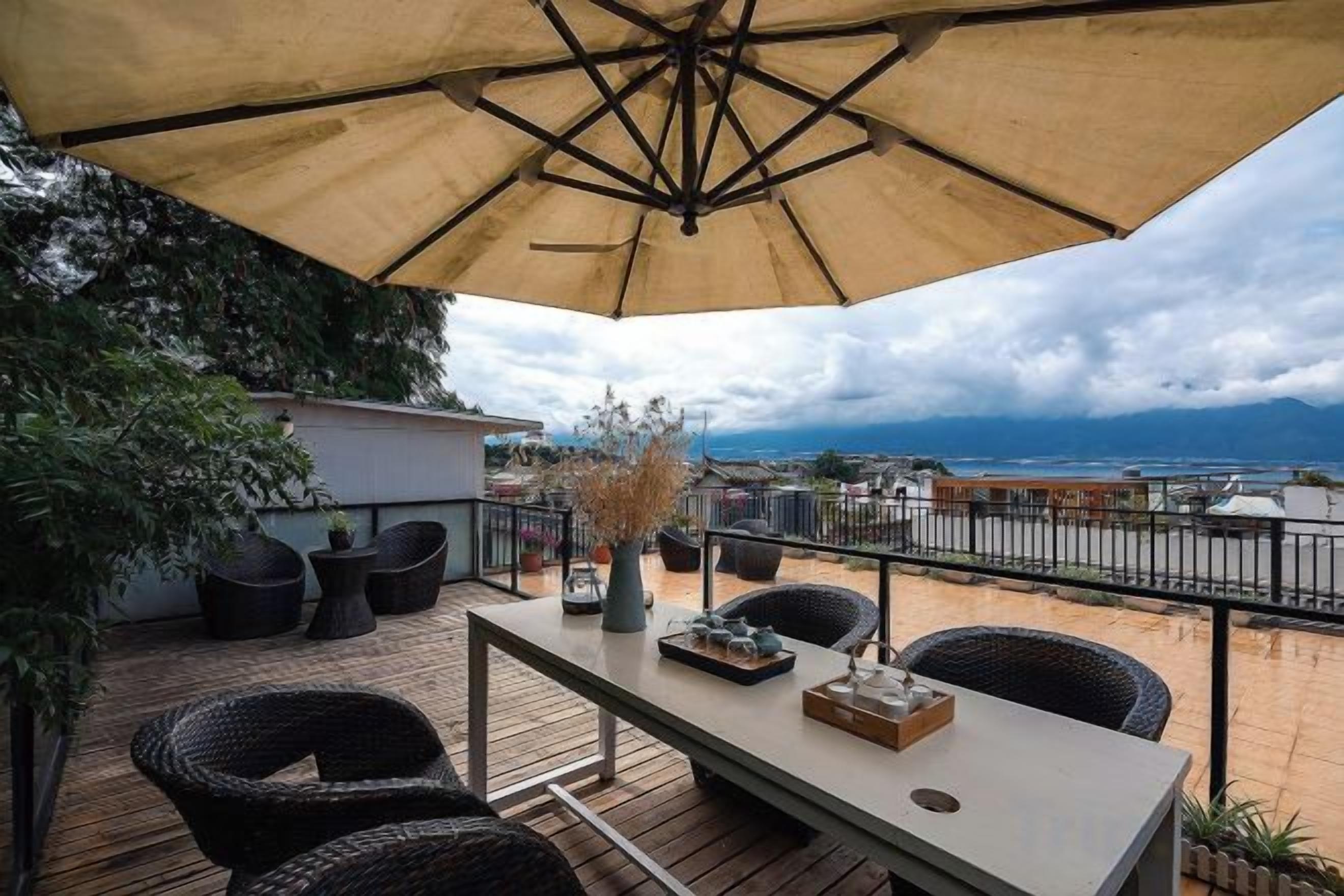 Un patio al aire libre con mesa, sillas y una sombrilla grande.