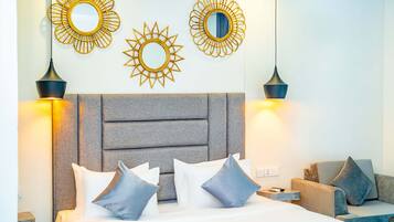 A hotel room with a bed, two wall-mounted mirrors, and two pendant lights.