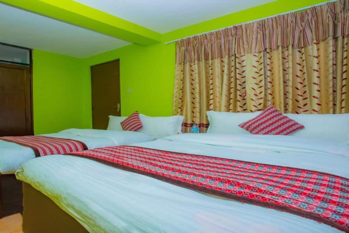 A room with two beds, a wardrobe, and a curtain.