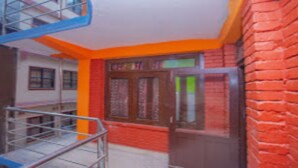 A building with a red brick exterior, a metal staircase, and a door with glass panels.