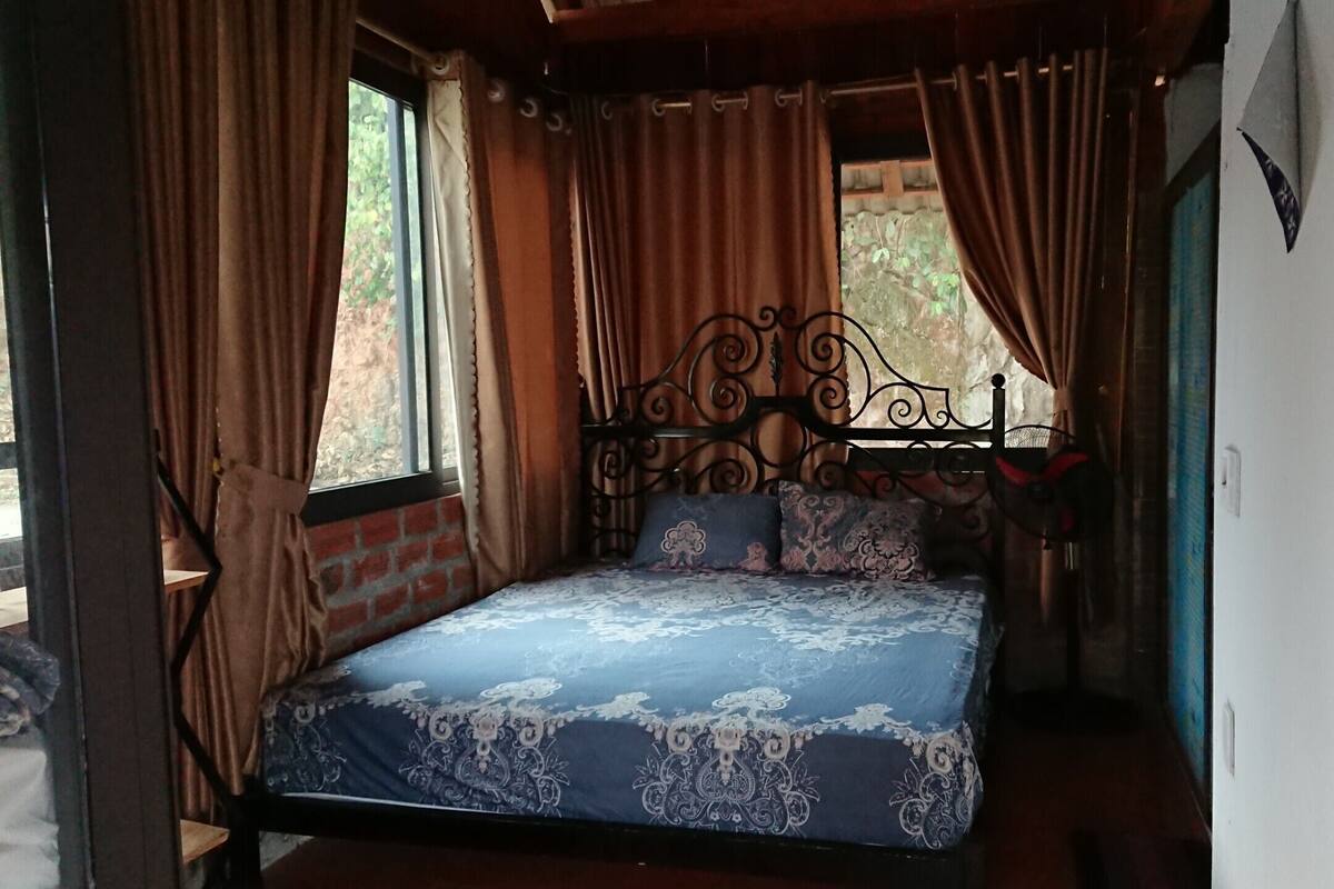 A bedroom with a bed, curtains, and a window.