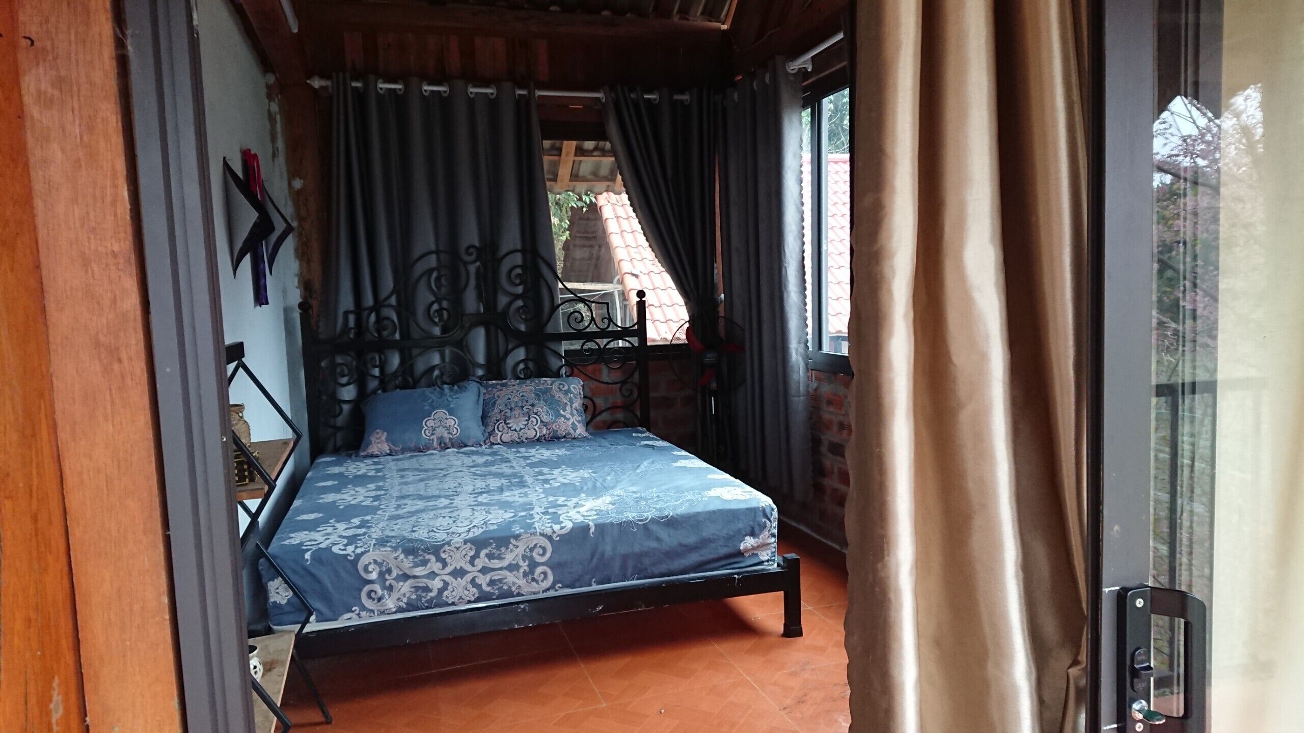 Ein Schlafzimmer mit Bett, Vorhängen und einem Fenster.