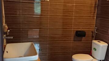 A bathroom with a bathtub, toilet, and a shower area.